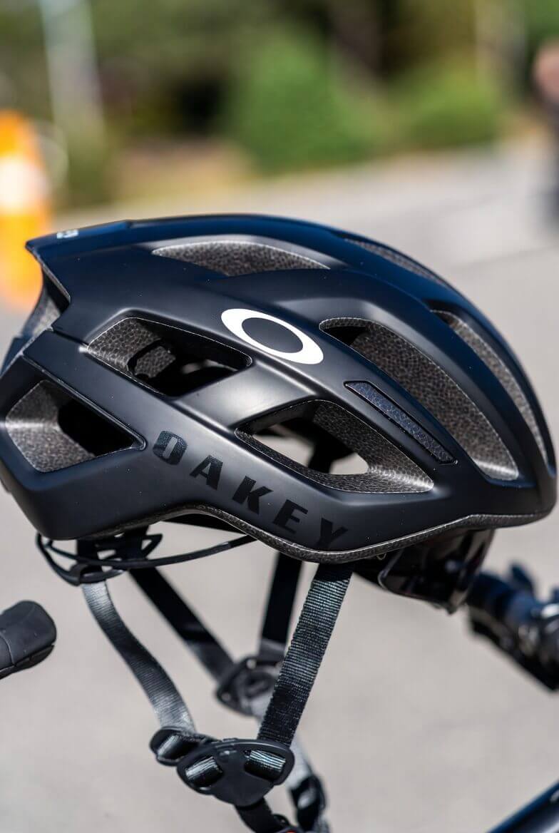 Темний велошолом Oakley із вентиляційними отворами біля велосипеда